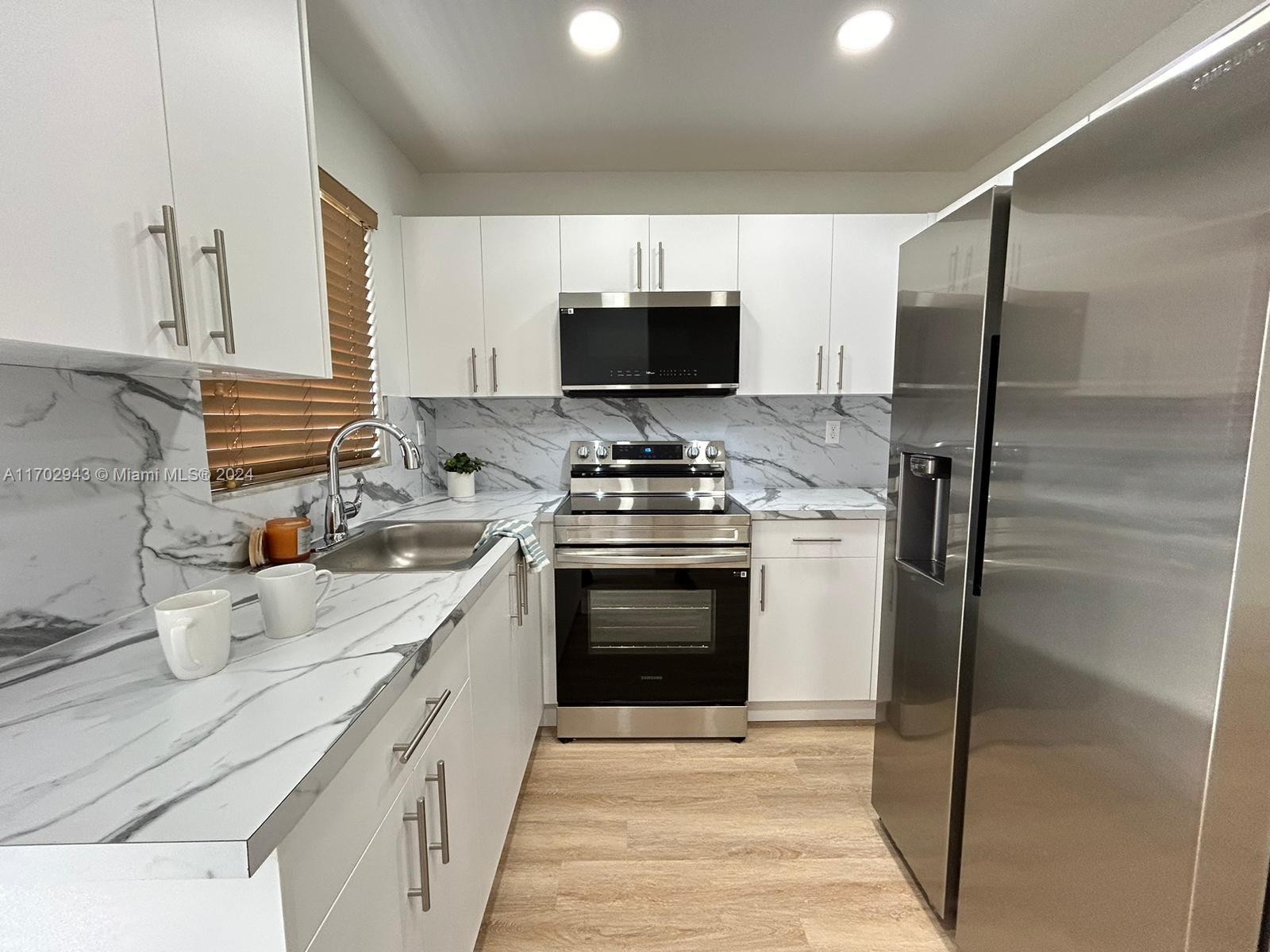 a kitchen with a sink stove and refrigerator