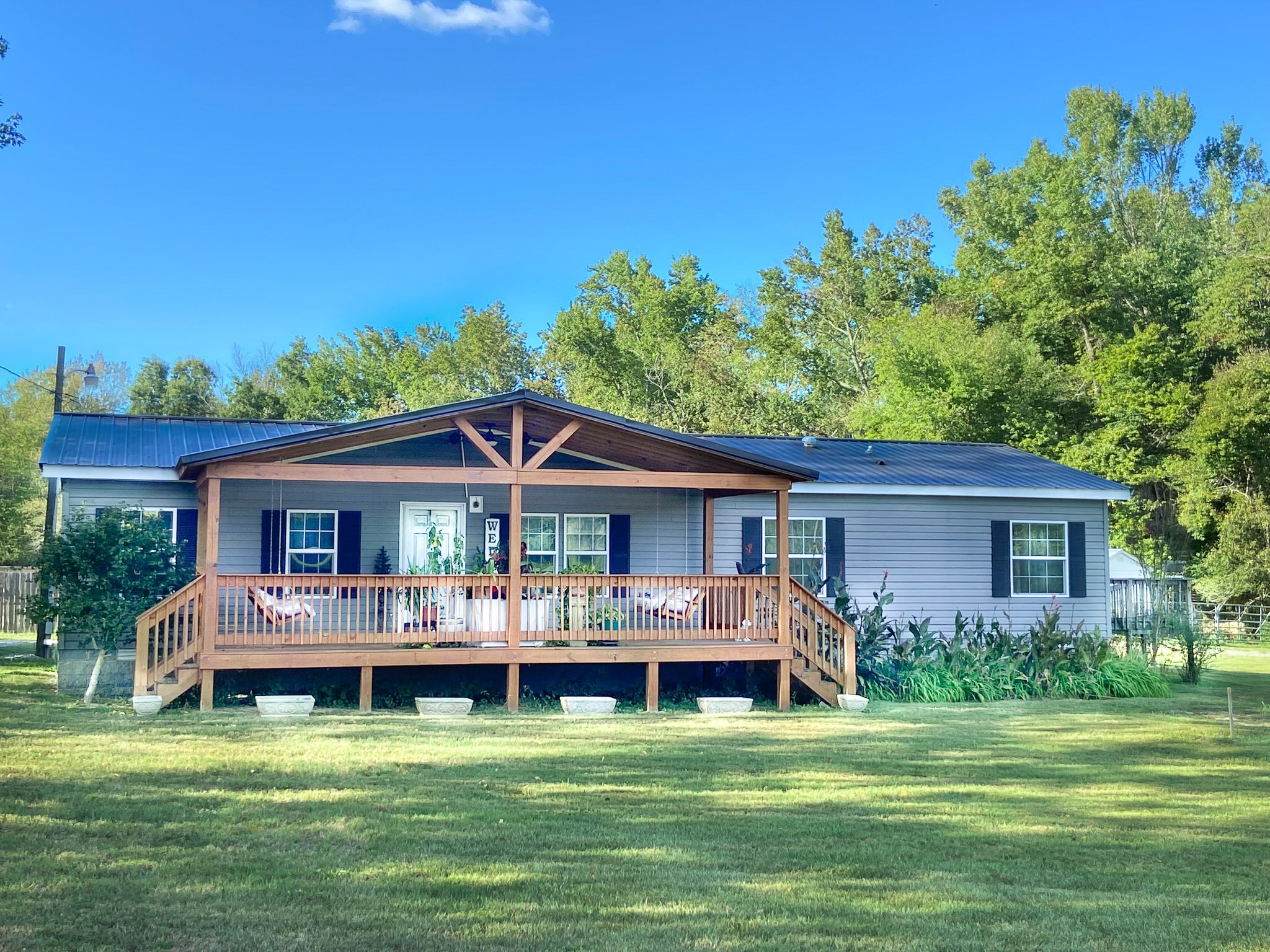 a view of a house with a yard deck and sitting area