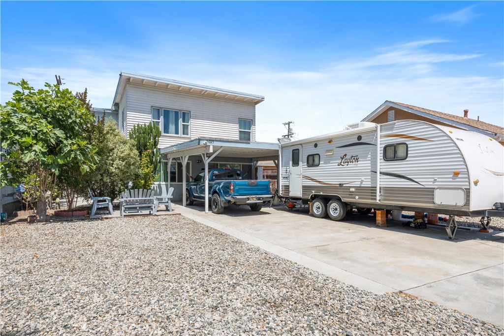 a view of a house with a large space and a car park in front of it