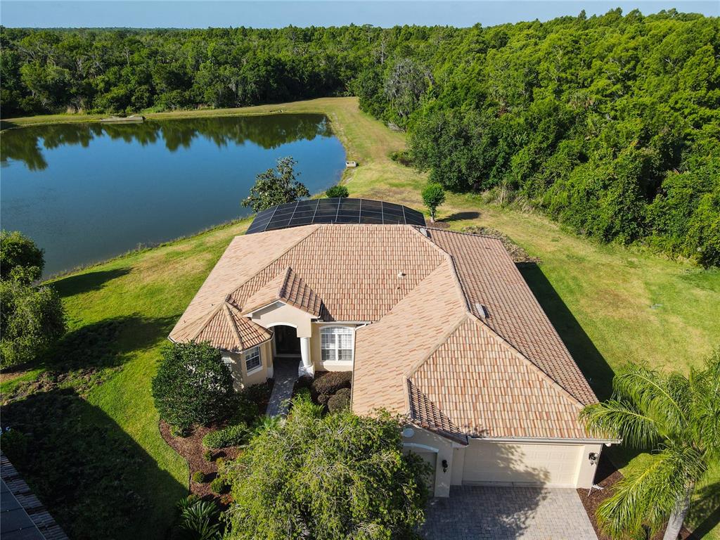 an aerial view of a house with a yard and lake view