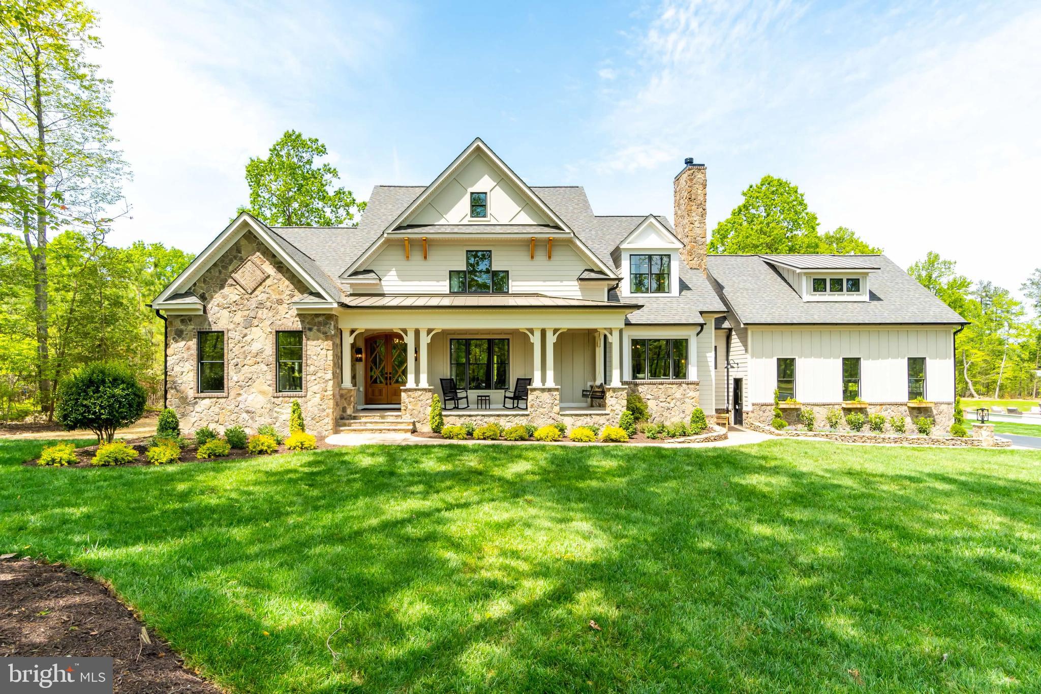 a front view of a house with garden and trees