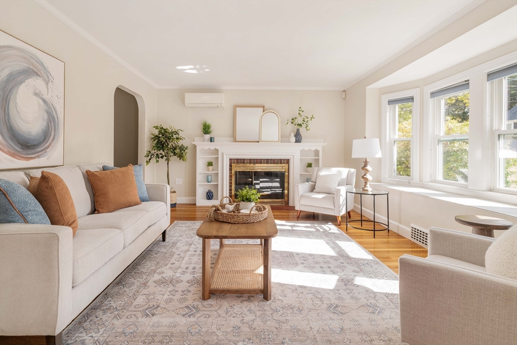 a living room with furniture a fireplace and a large window