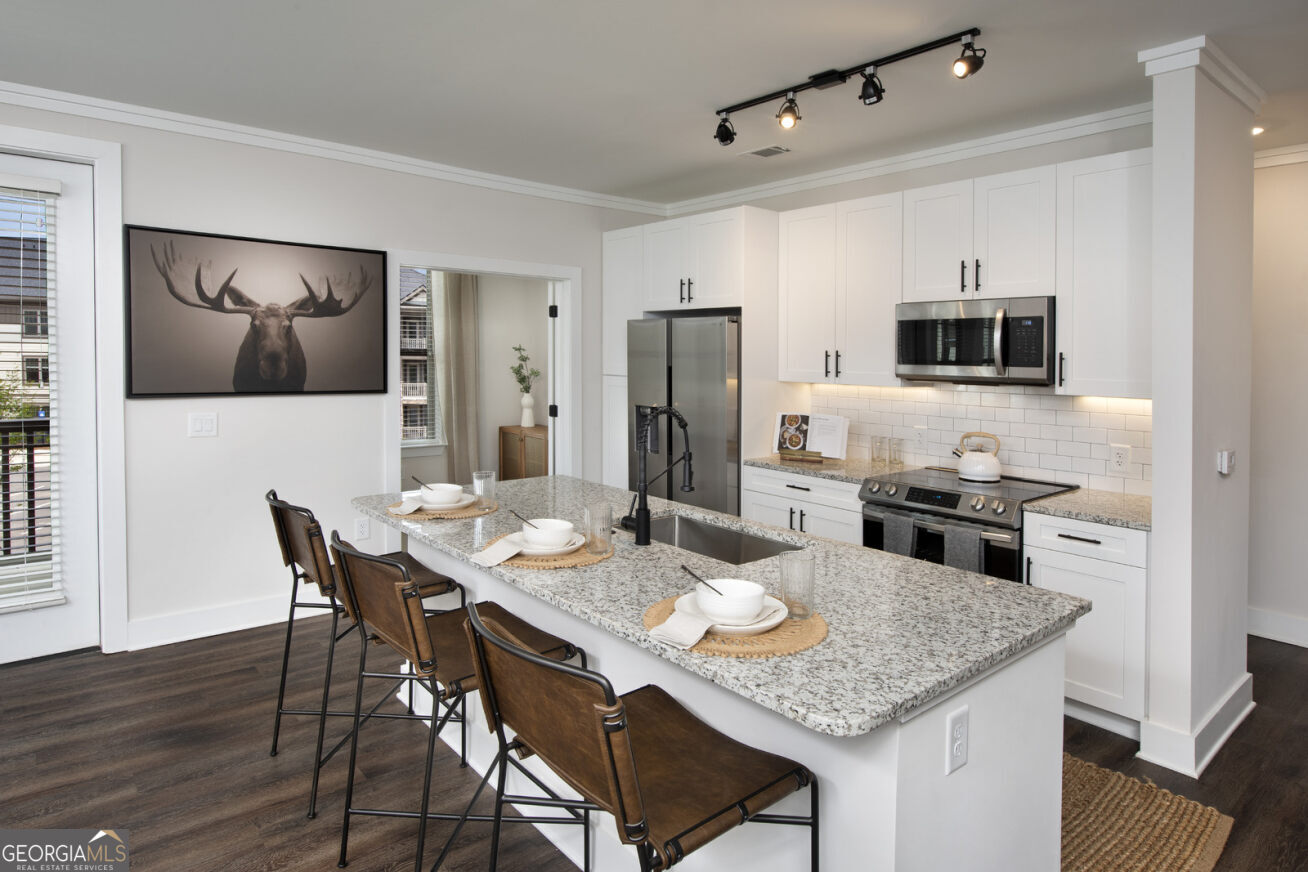 a kitchen with stainless steel appliances kitchen island granite countertop a dining table and chairs with wooden floor