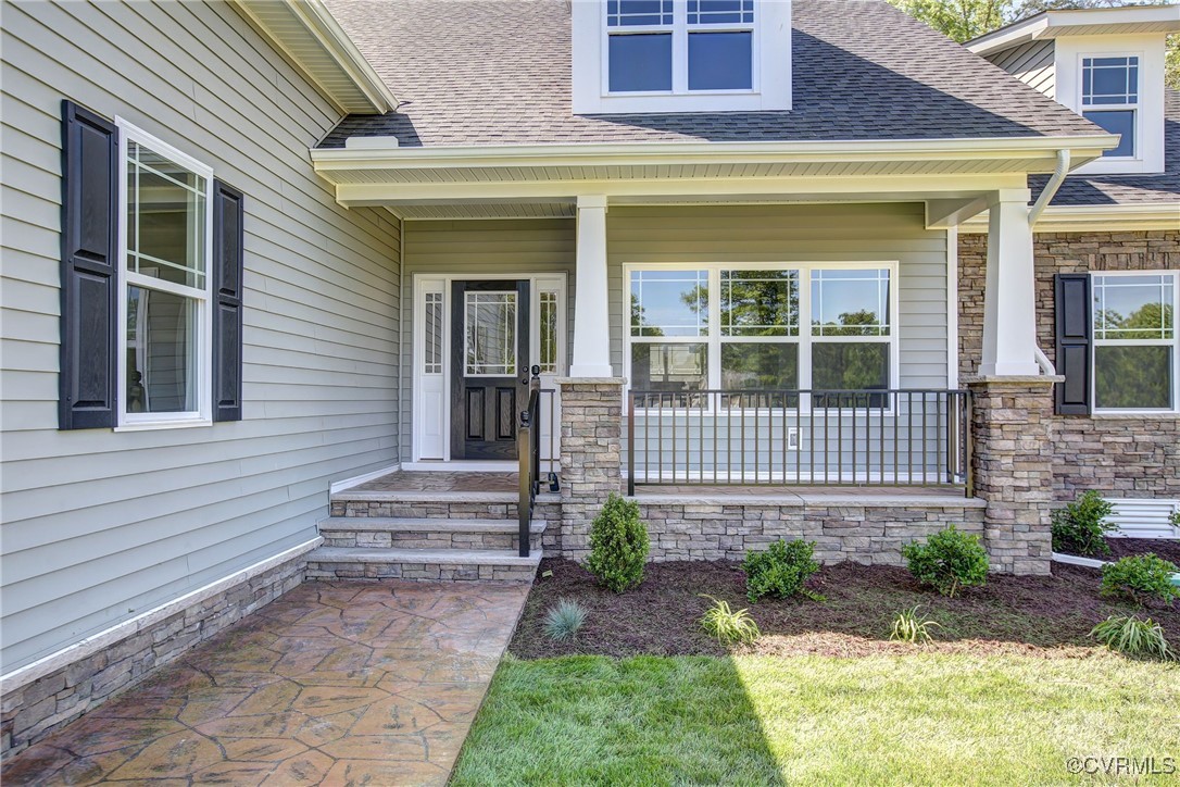 View of exterior entry featuring covered porch