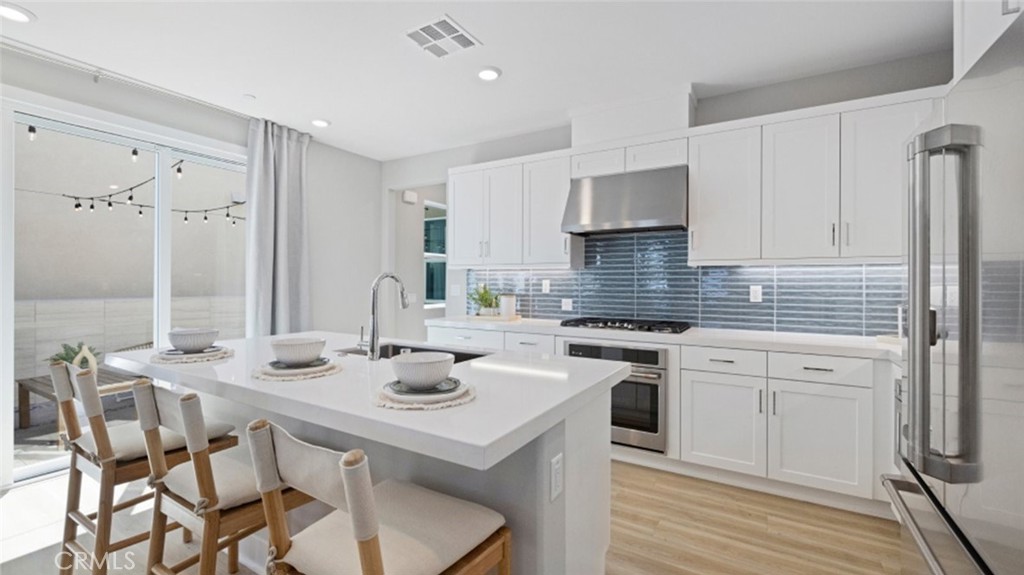 a kitchen with stainless steel appliances granite countertop a white cabinets and a stove top oven