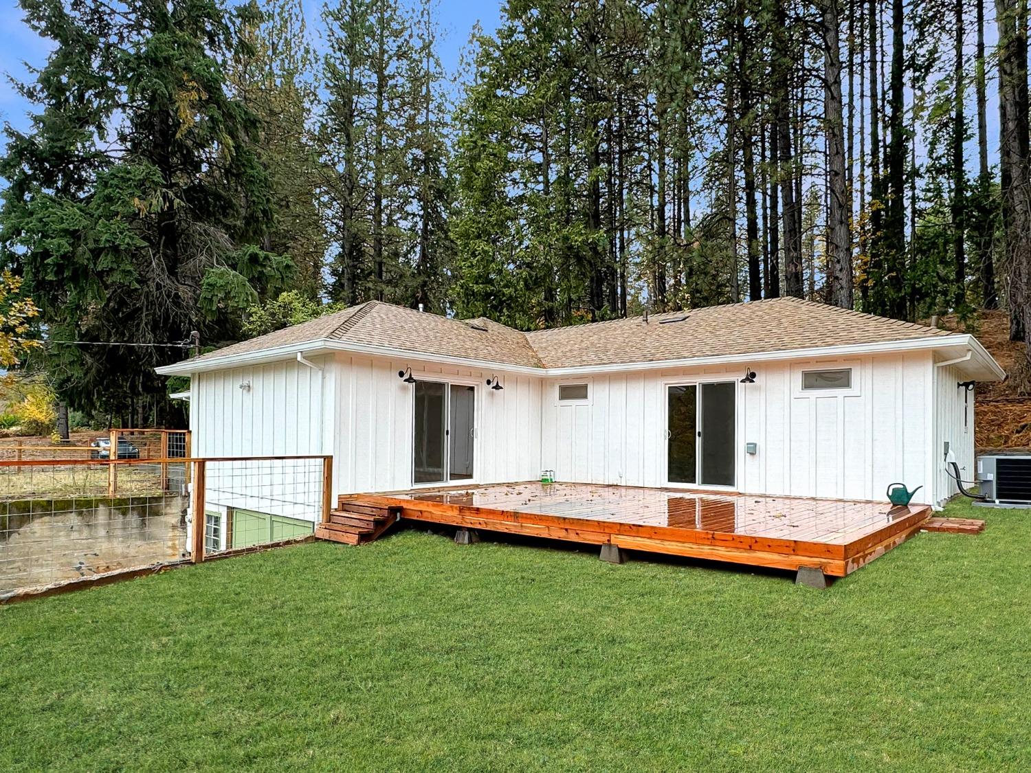 a front view of house with yard and trees in the background