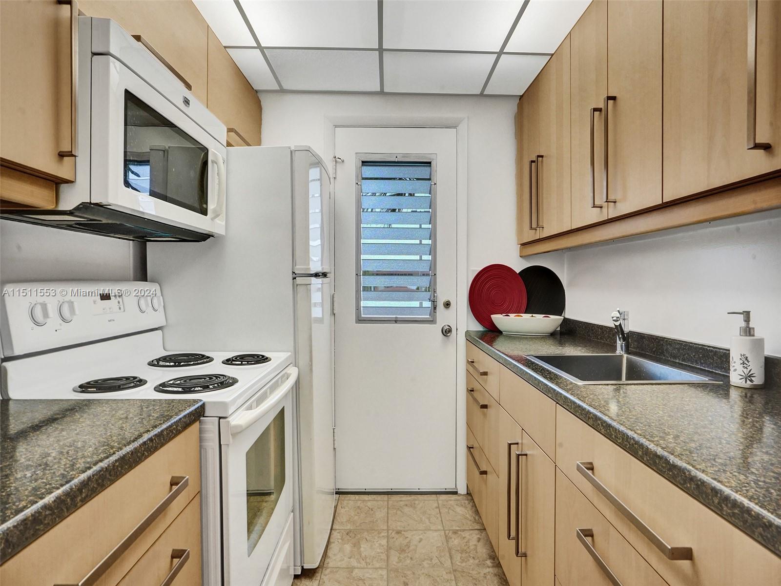 a kitchen with stainless steel appliances granite countertop a sink and a stove