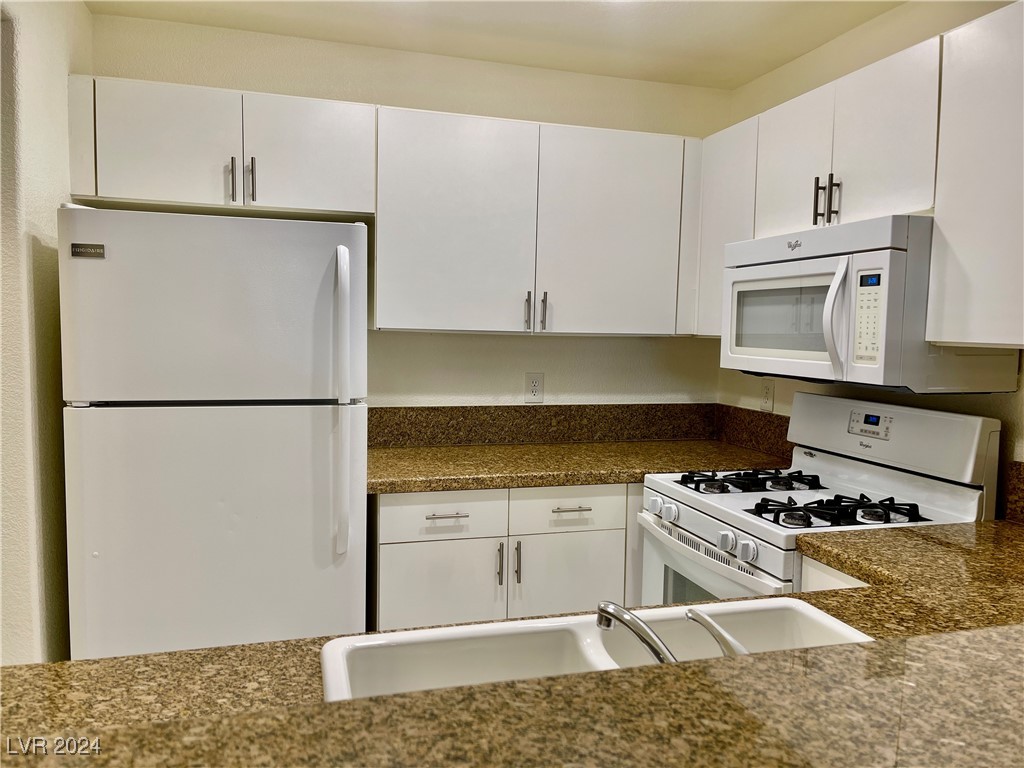 Nice kitchen with white appliances, granite counte