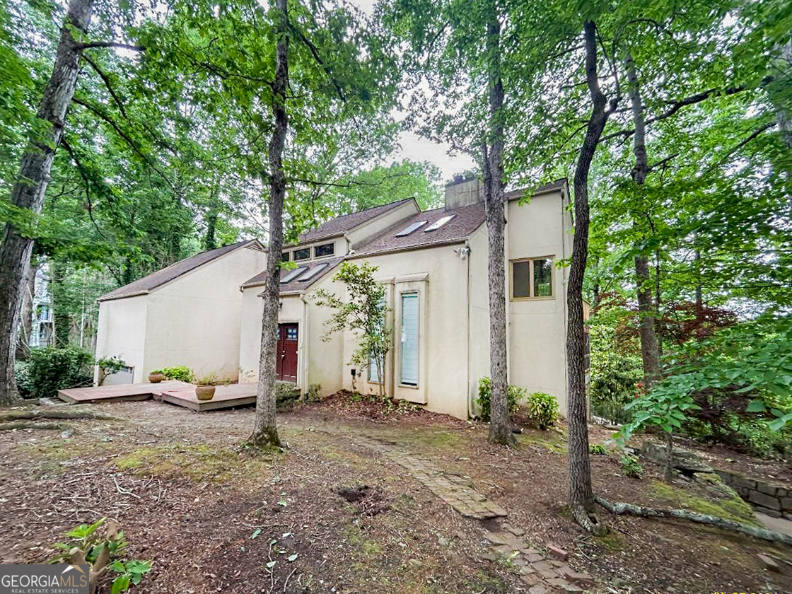 a view of a house with backyard and a tree