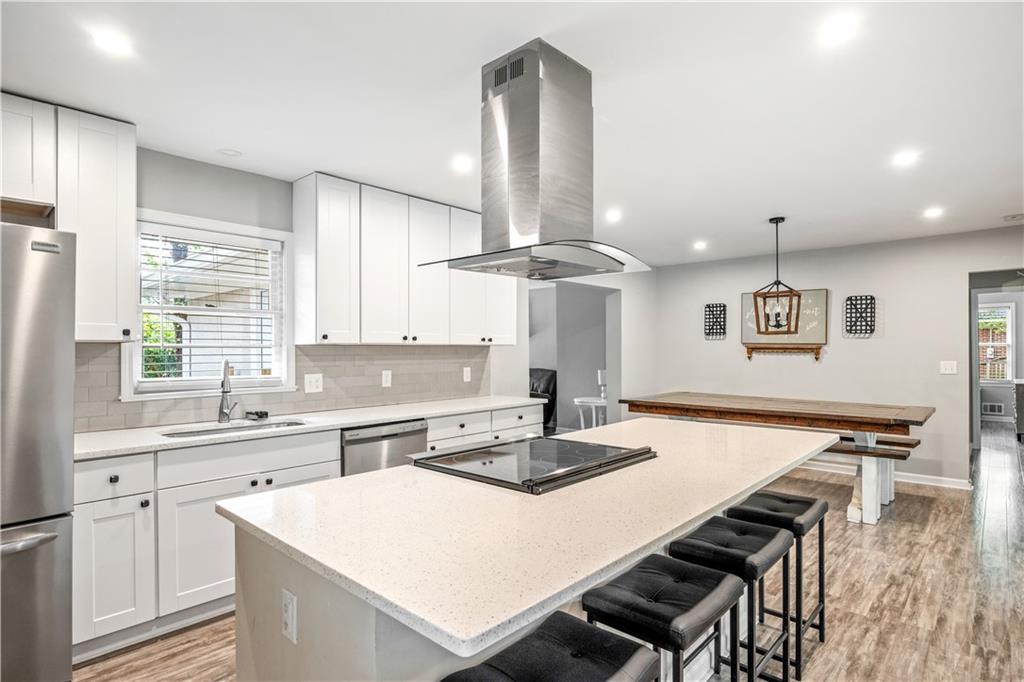 a kitchen with a table chairs stove and wooden floor