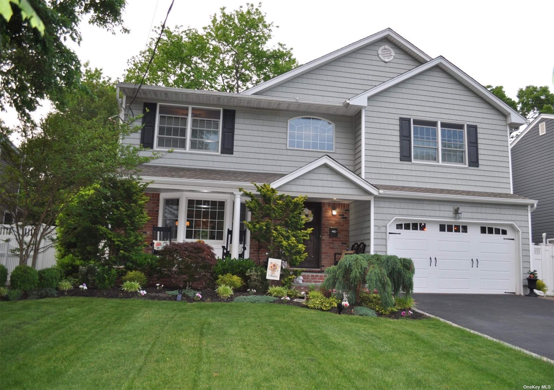 a front view of a house with a garden and yard