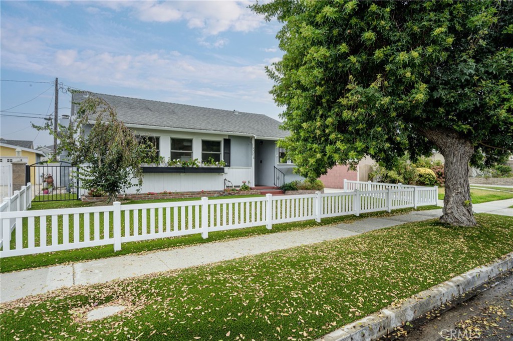 a view of a house with a yard and fence