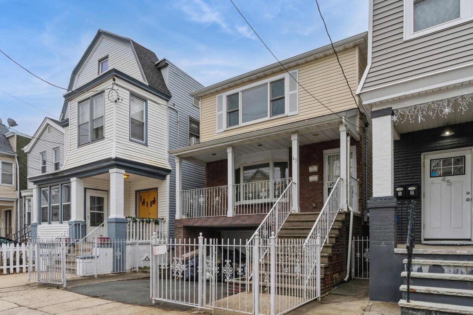 a front view of a house with iron fence