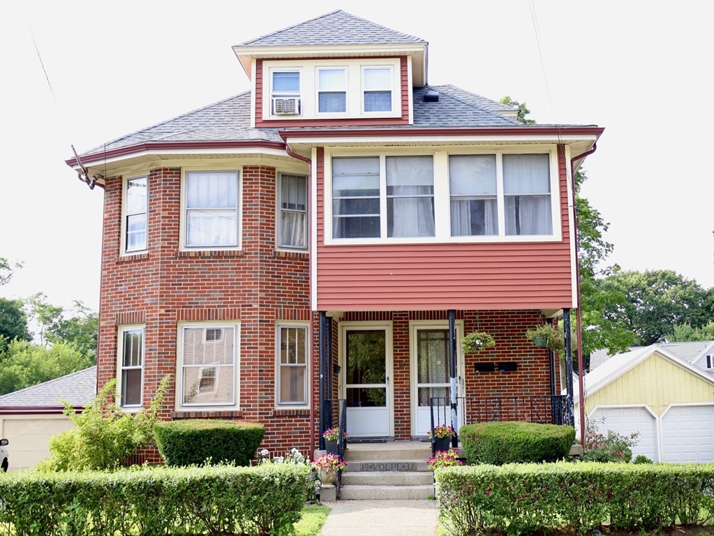 front view of a brick house with a small yard