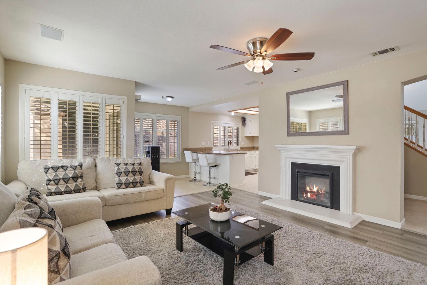 a living room with furniture a fireplace and a large window