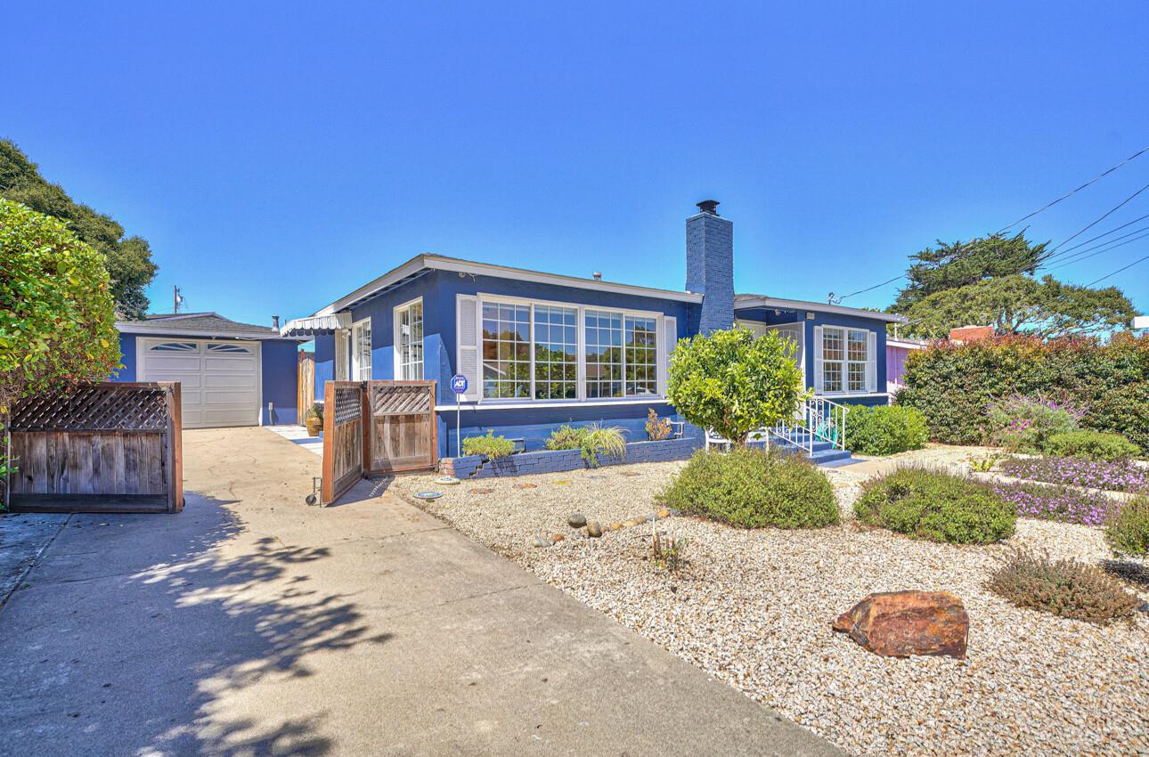 a front view of a house with a yard and potted plants