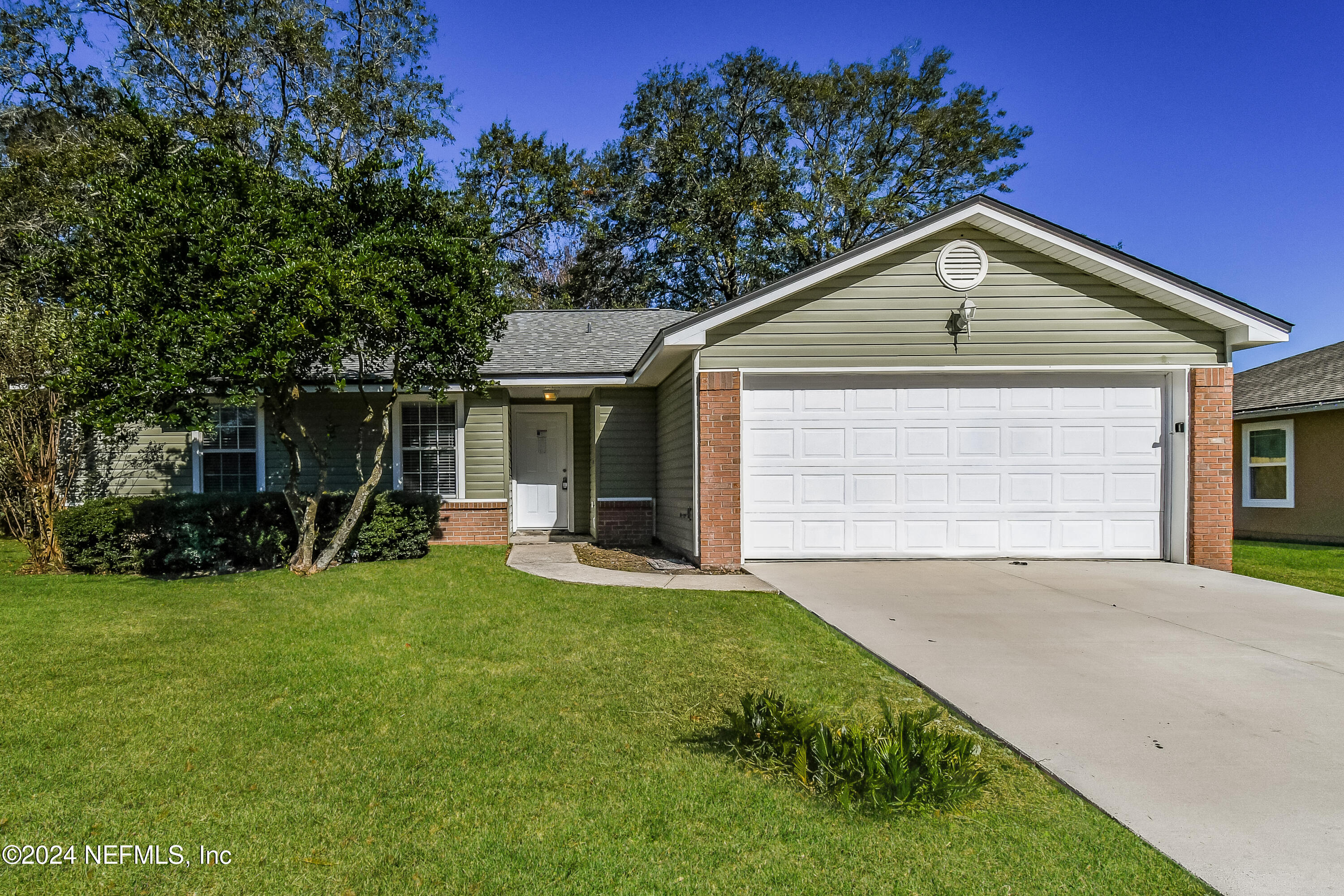 a front view of a house with a yard and trees