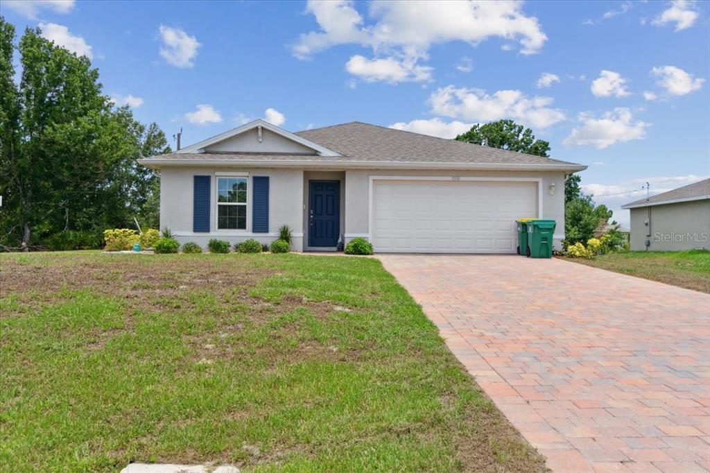 a front view of a house with a yard and trees