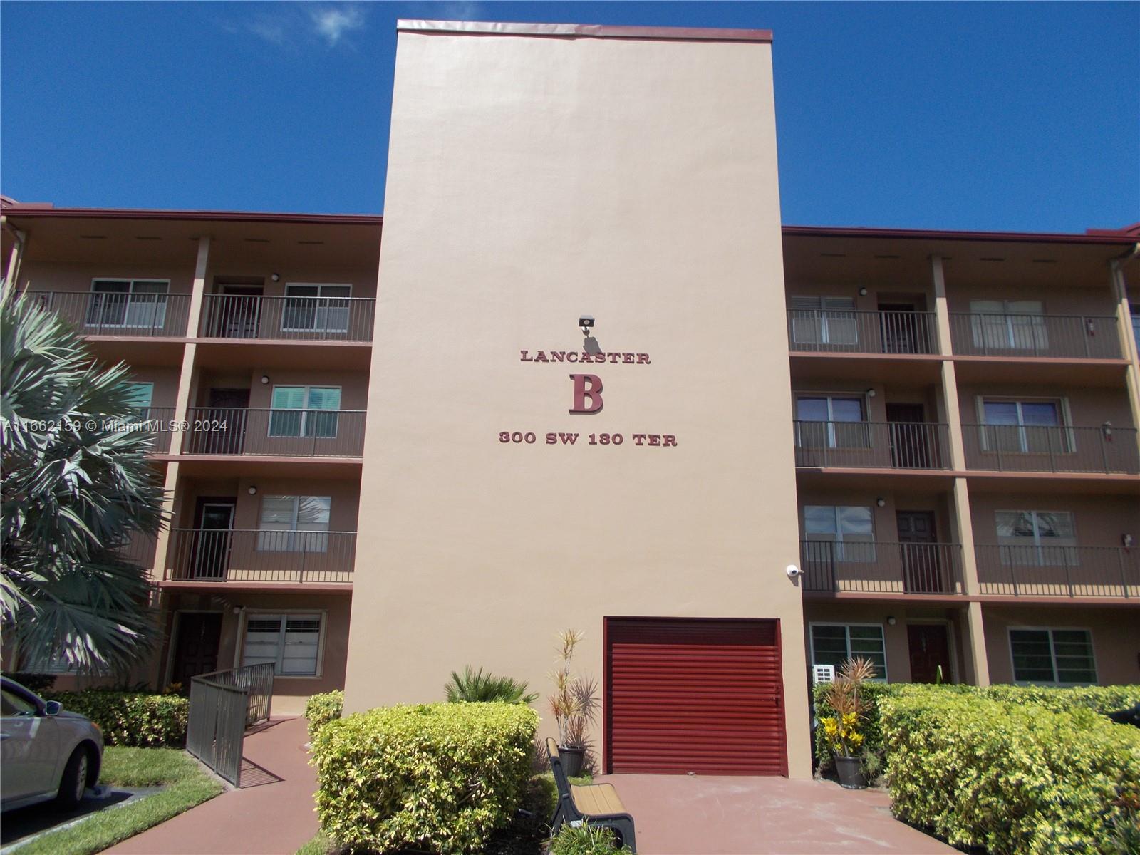 a front view of a building with a garden