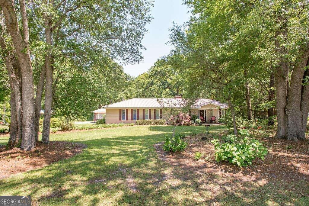 a front view of a house with a yard and trees