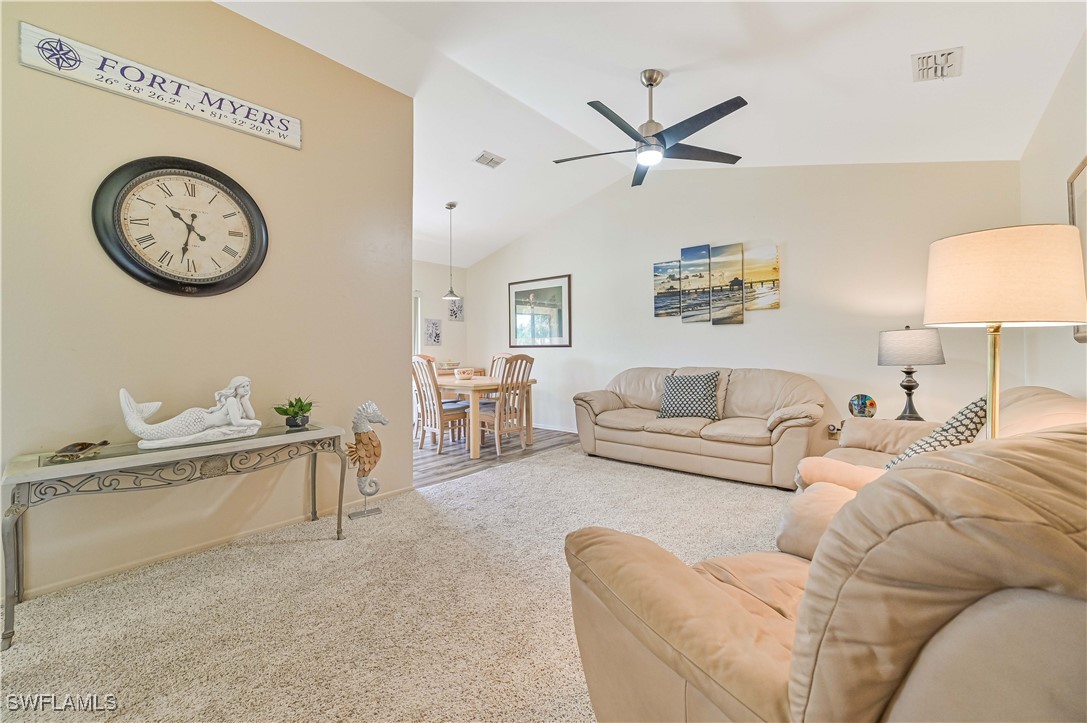 a living room with furniture a clock and a ceiling fan