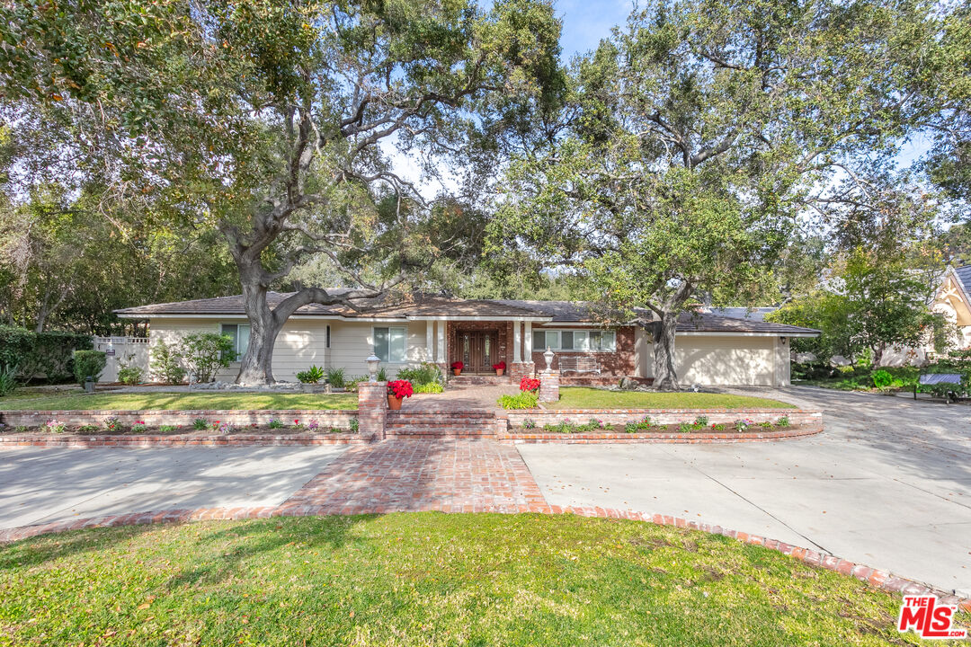 a view of a house with backyard and trees