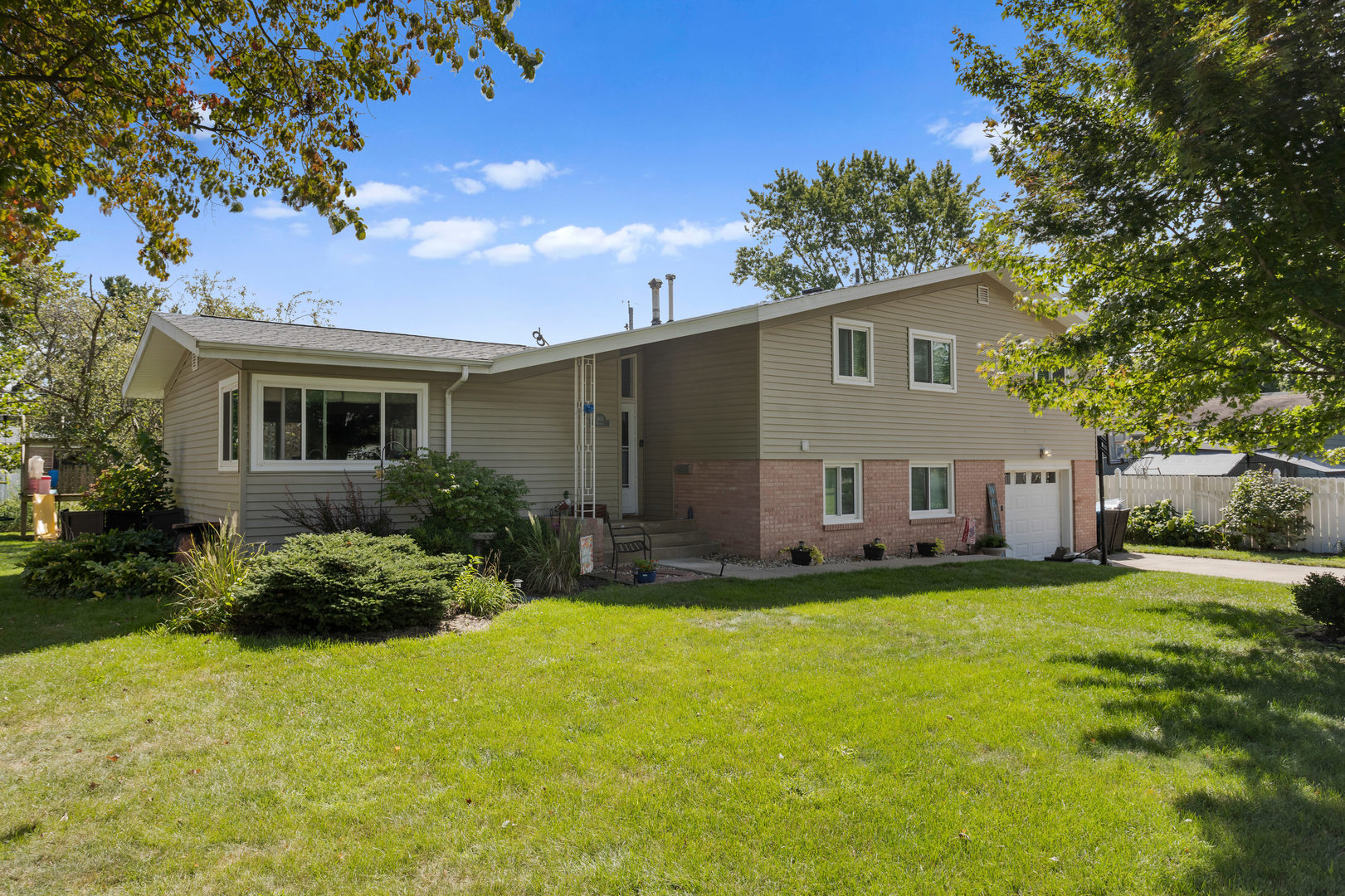 a front view of house with yard and trees in the background