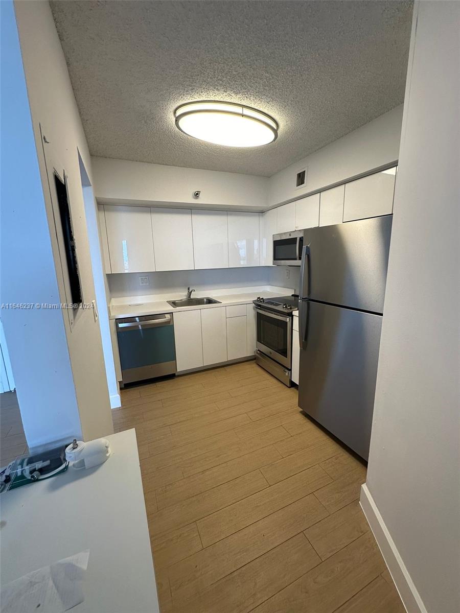 a kitchen with stainless steel appliances granite countertop a refrigerator and a stove top oven