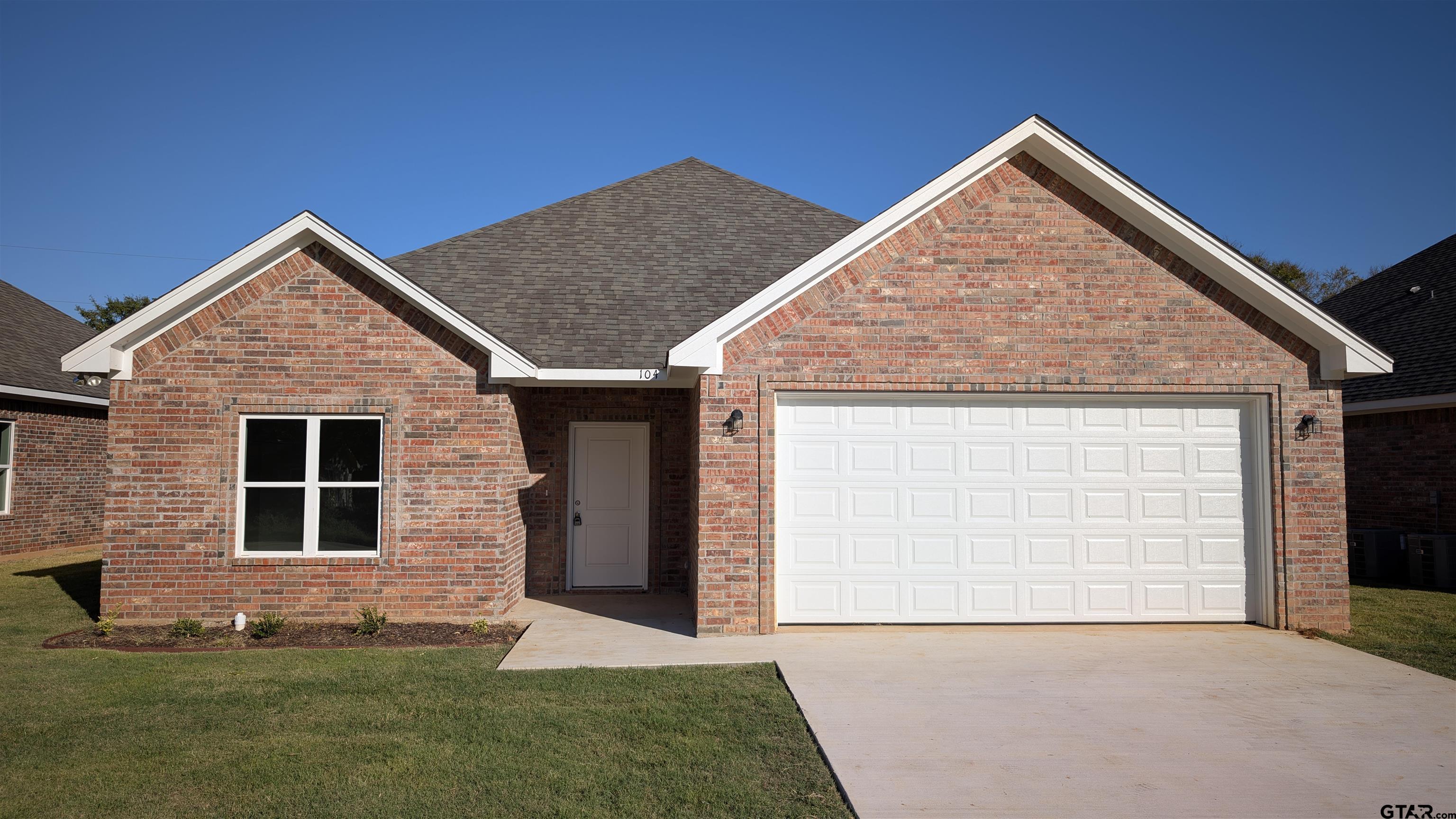 a front view of a house with a garden and yard