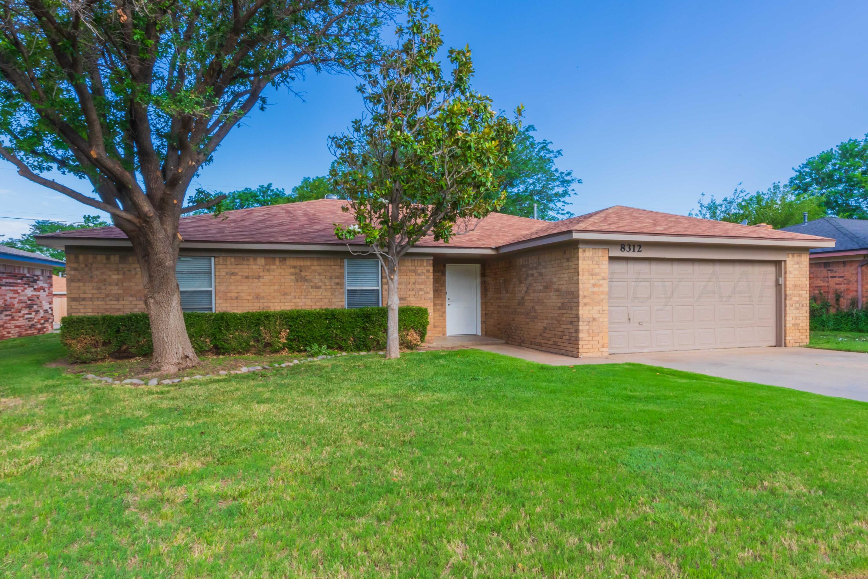 a front view of a house with a garden and yard