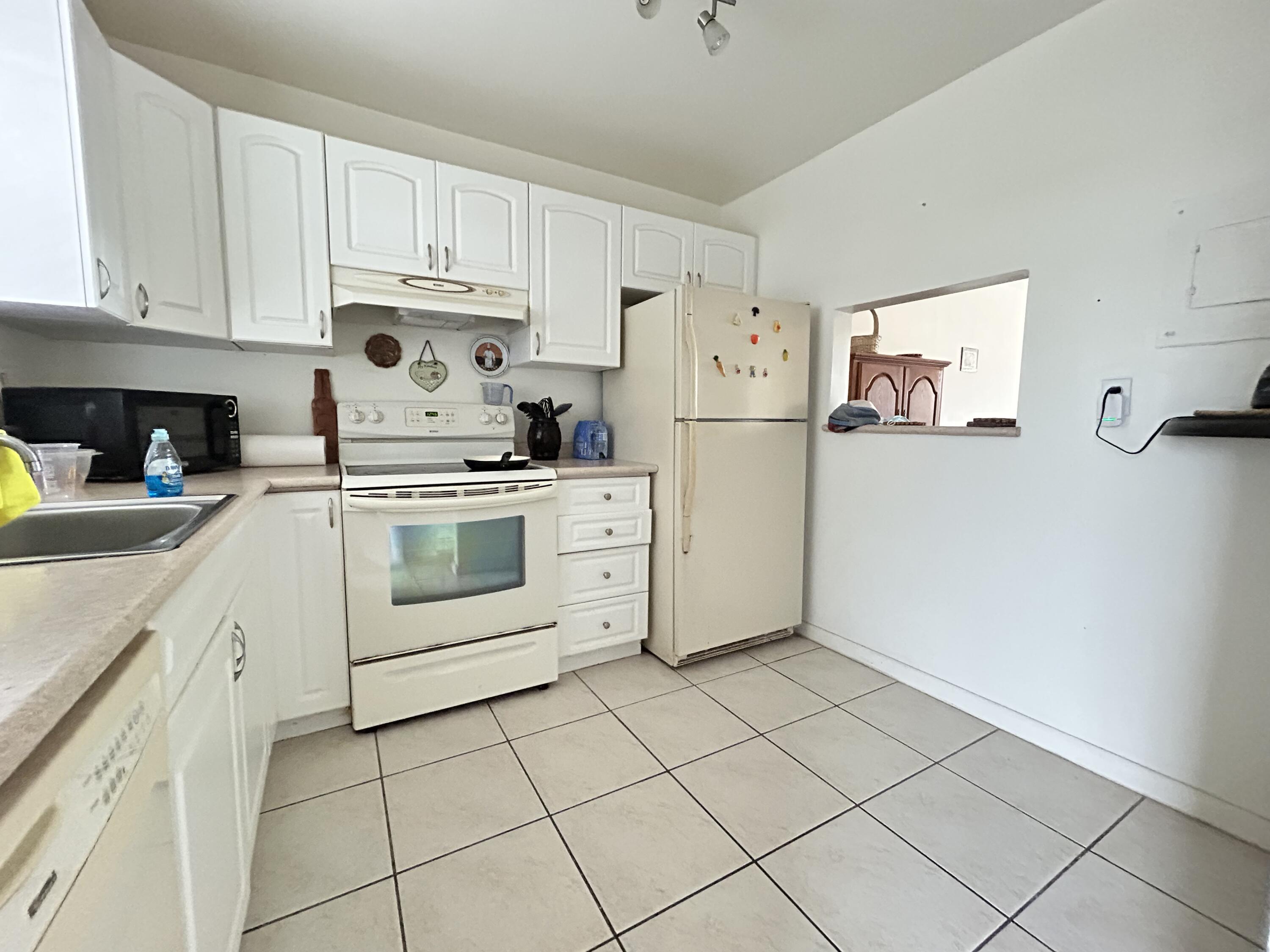 a kitchen with white cabinets and white appliances