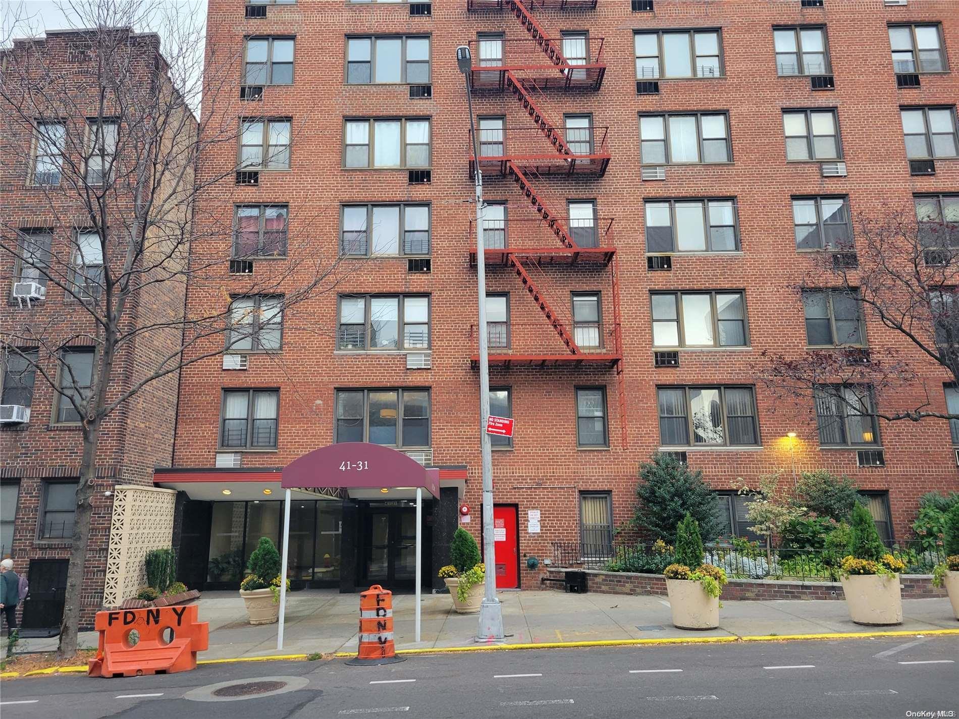 a street with tall buildings and a yard in front of it