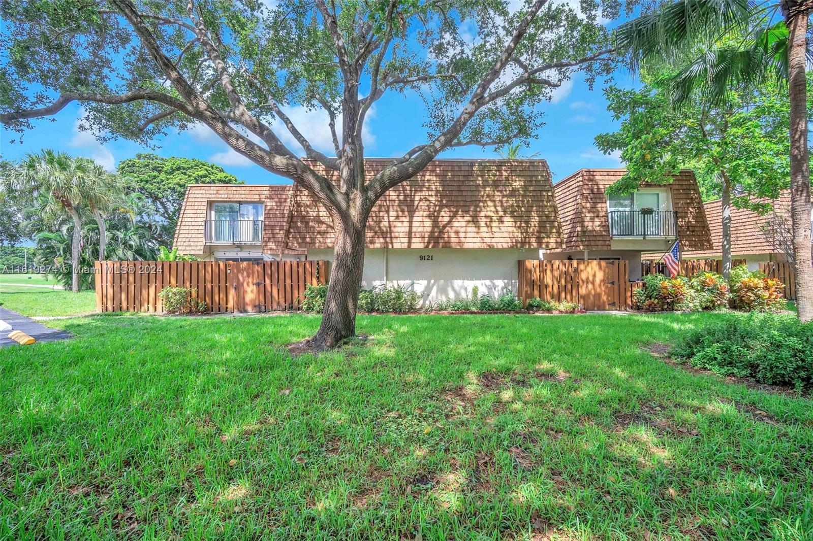 a view of a house with backyard and a tree