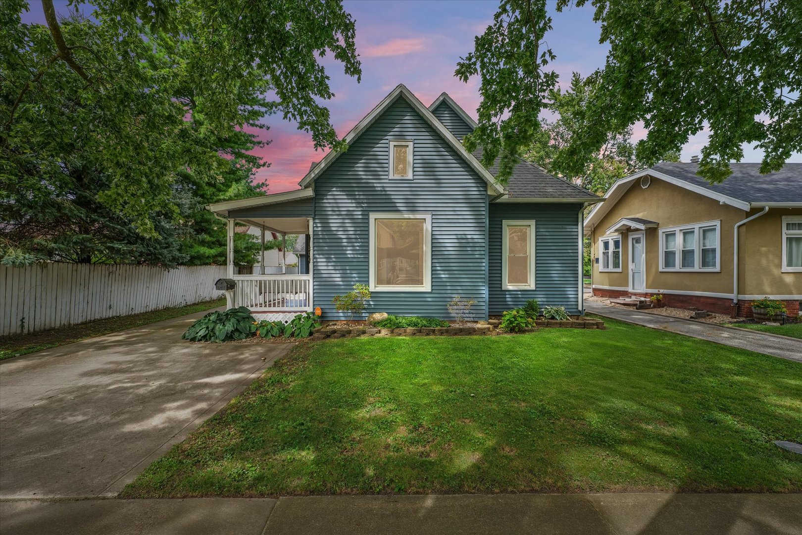 a front view of a house with yard and green space