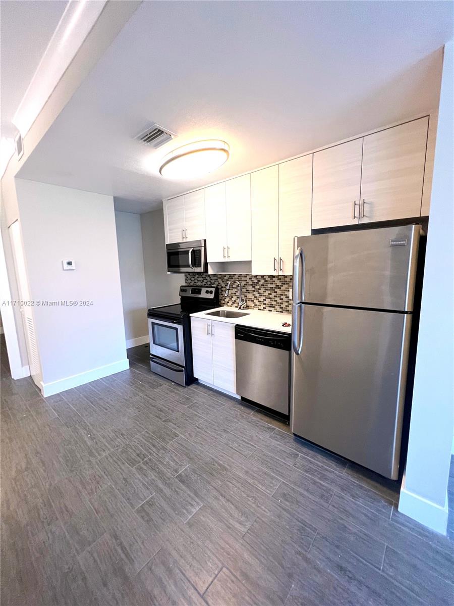 a kitchen with a refrigerator a stove top oven and a refrigerator