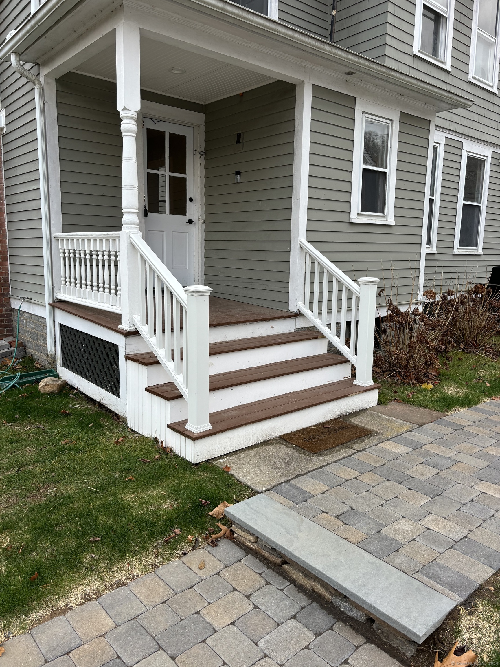 a view of a house with a small yard and wooden fence