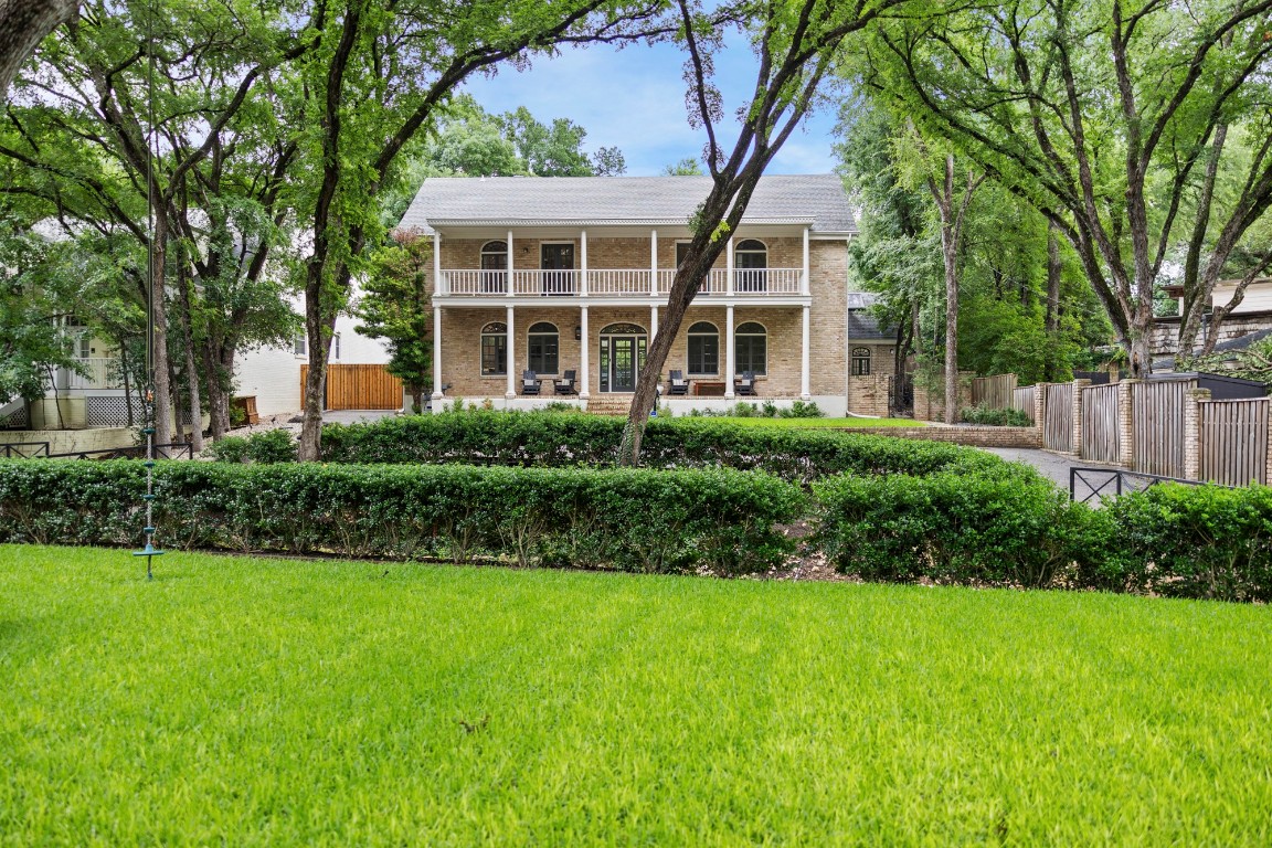 a front view of a house with a yard and potted plants