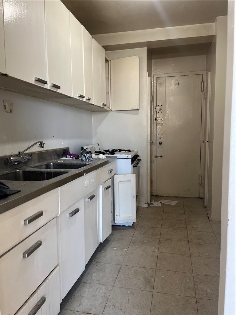 a kitchen with granite countertop white cabinets and white appliances