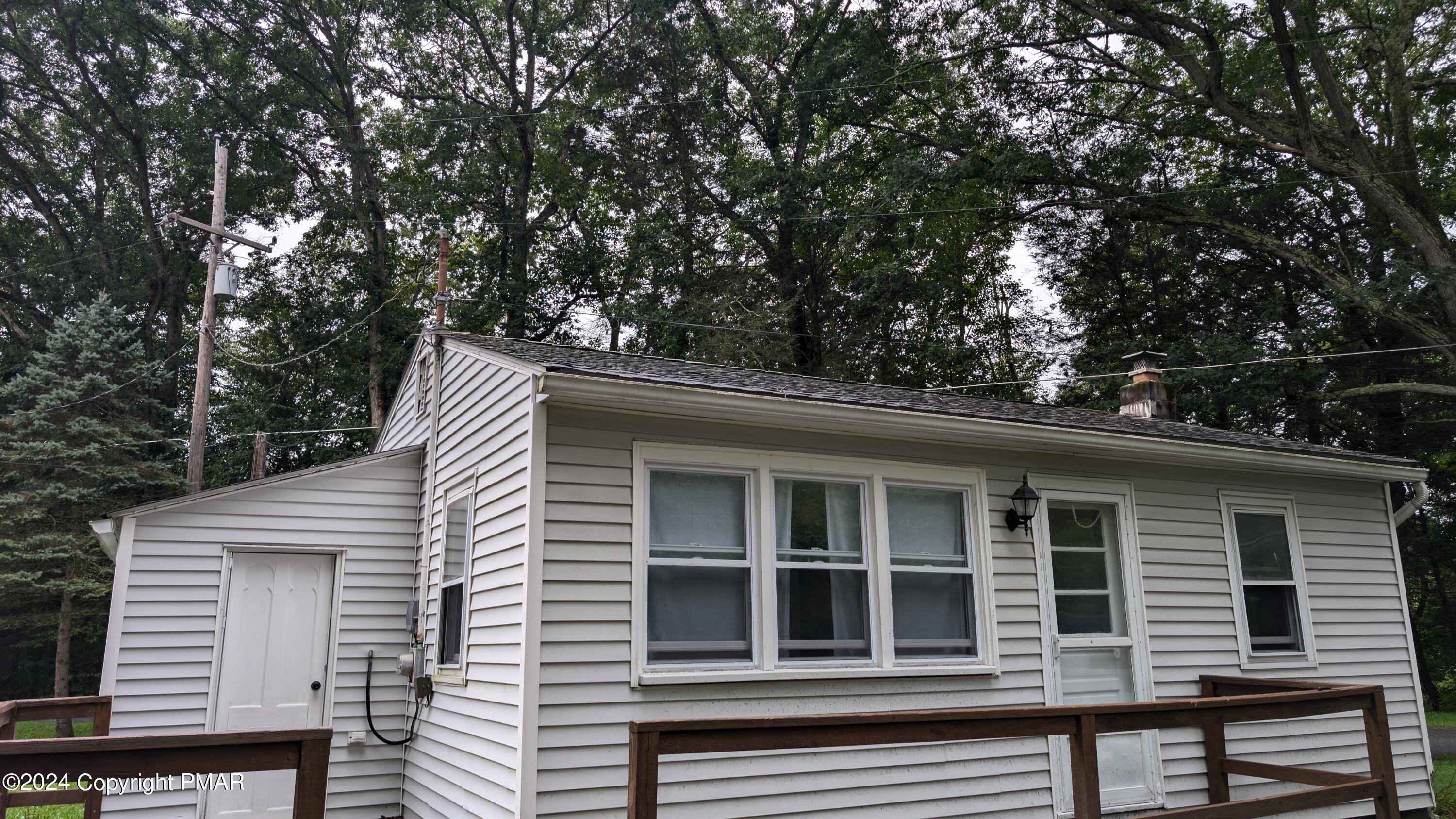 a front view of a house with a tree