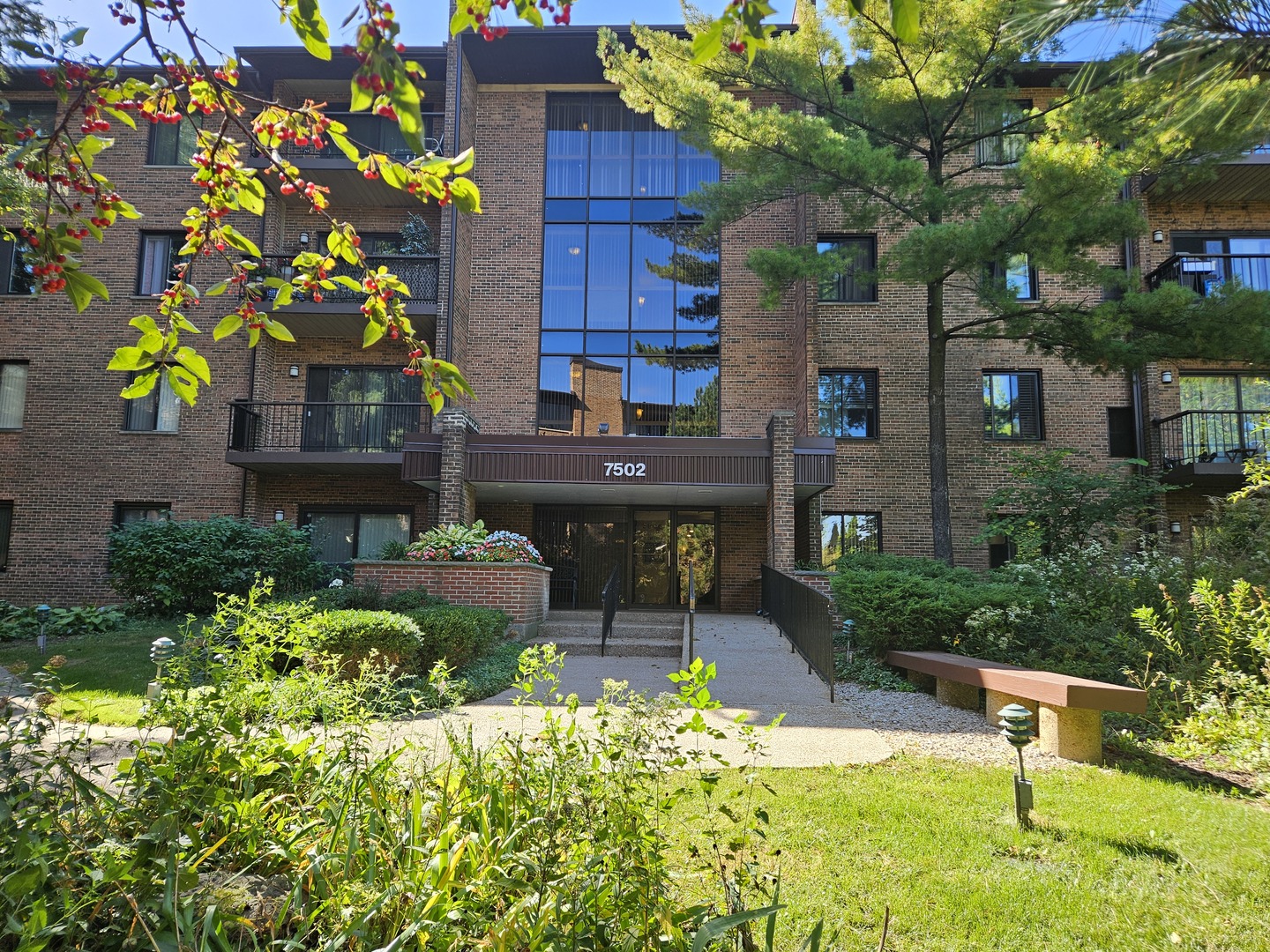 a front view of a house with a yard and fountain in middle