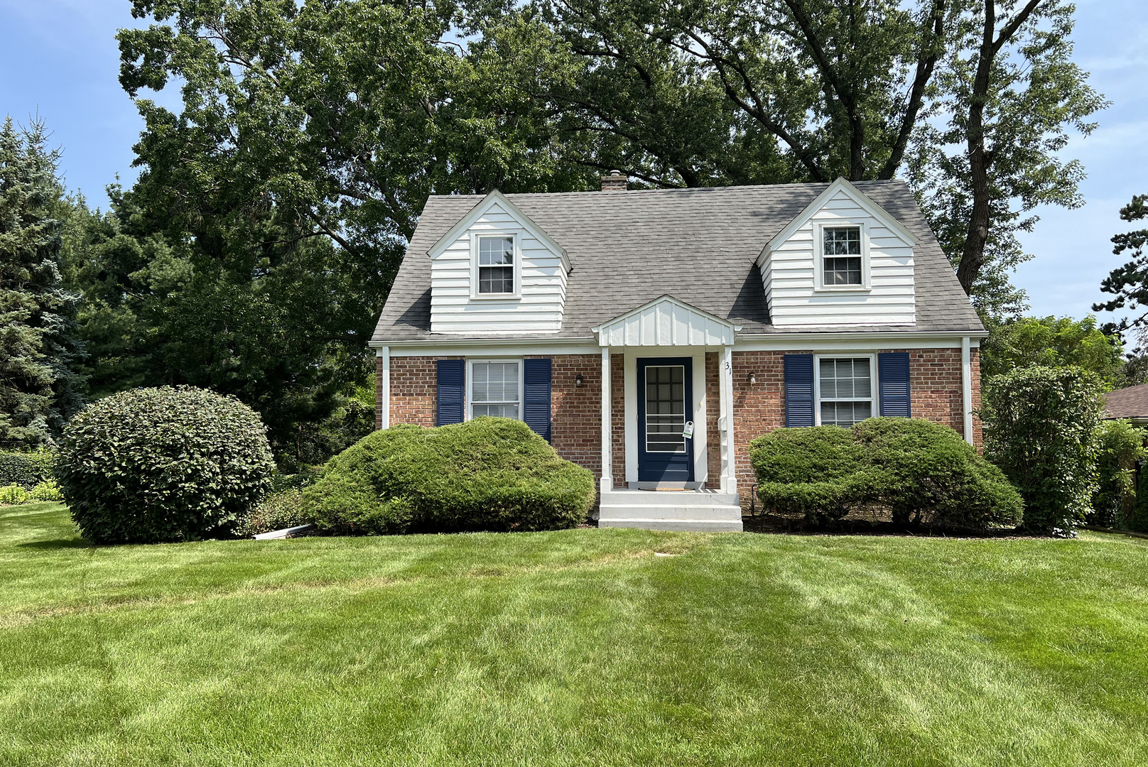 a front view of a house with a garden