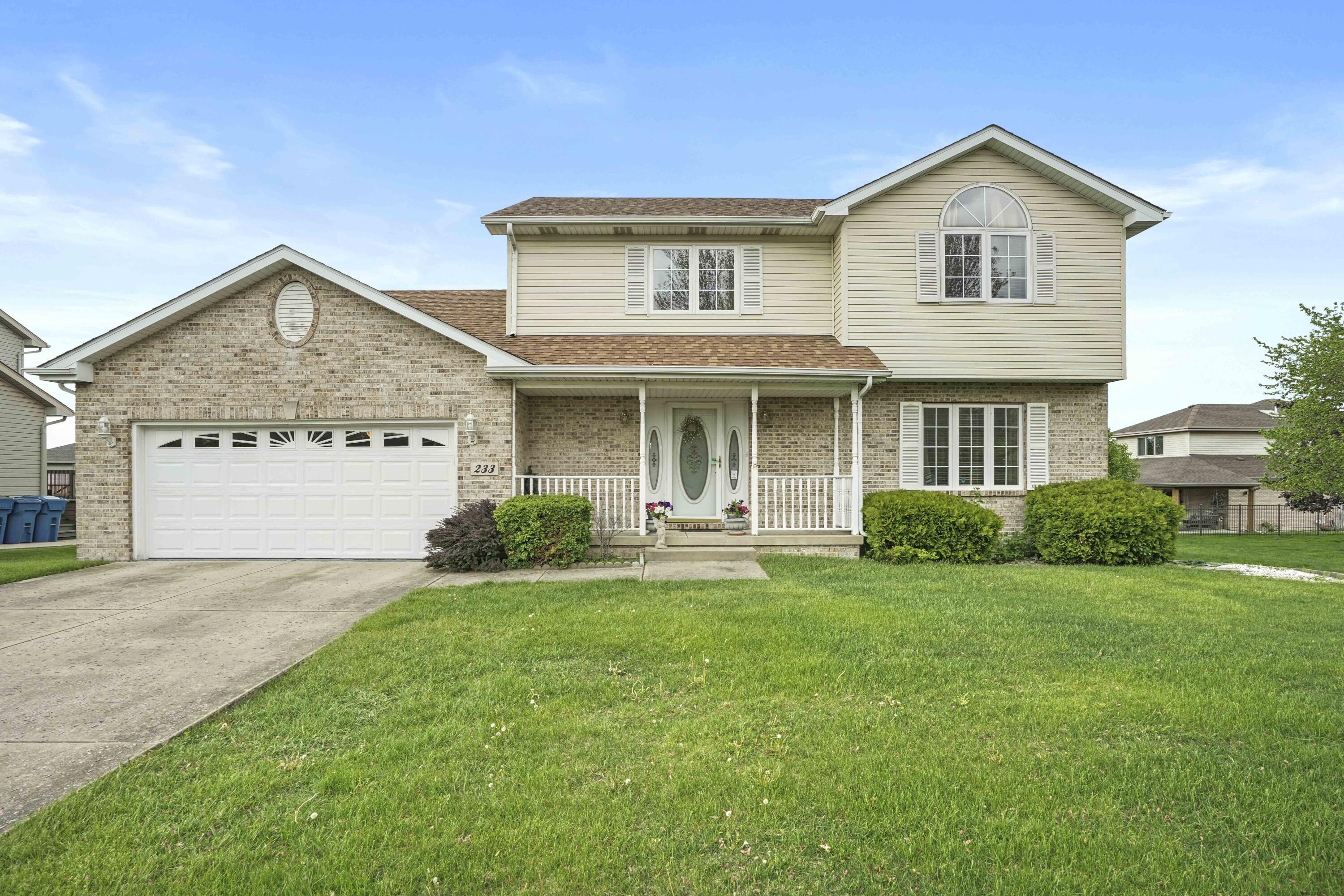 a front view of a house with a yard and garage