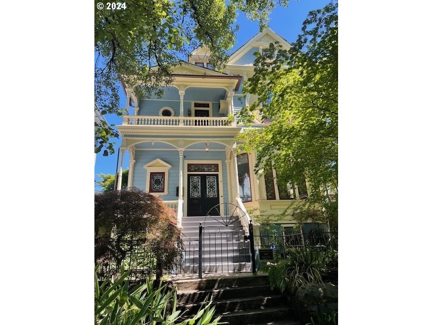 a front view of a house with a tree