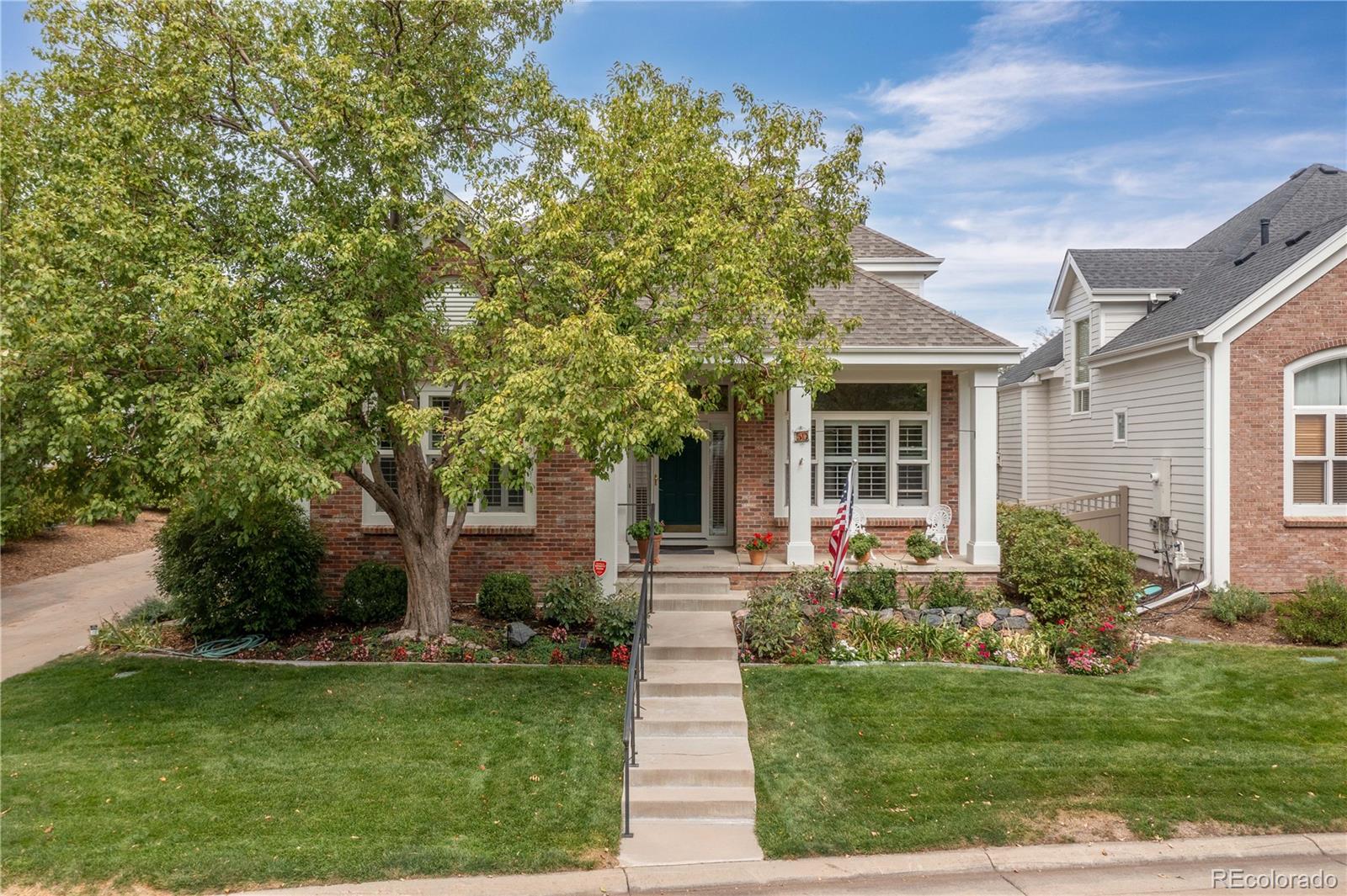 a front view of a house with a yard and potted plants