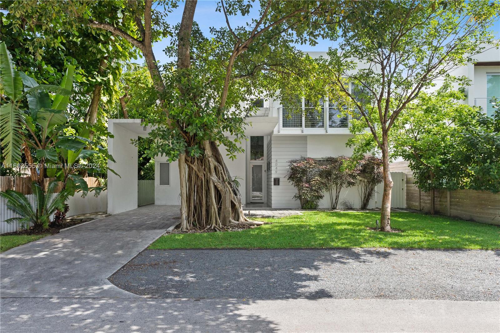 a front view of a house with a tree and a yard