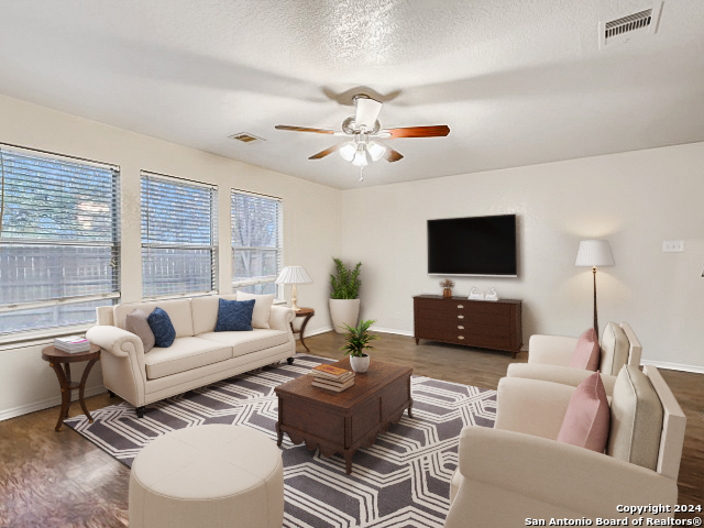 a living room with furniture a flat screen tv and a large window