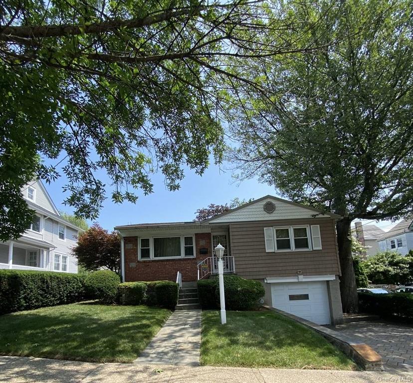 View of front facade with a front yard and a garage