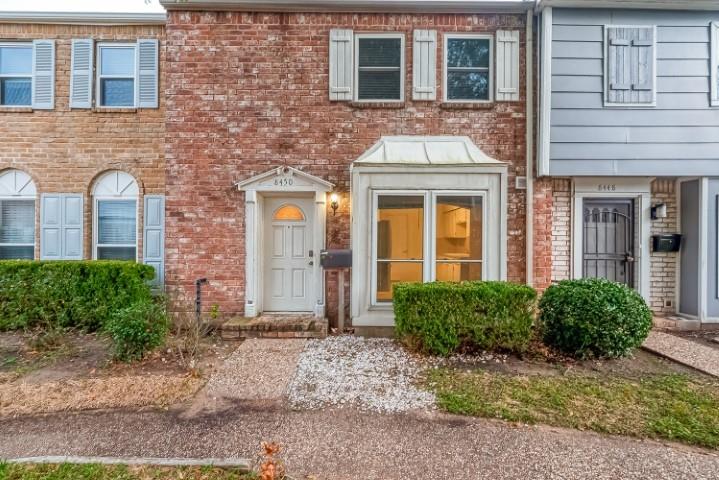 a front view of a brick house with a yard