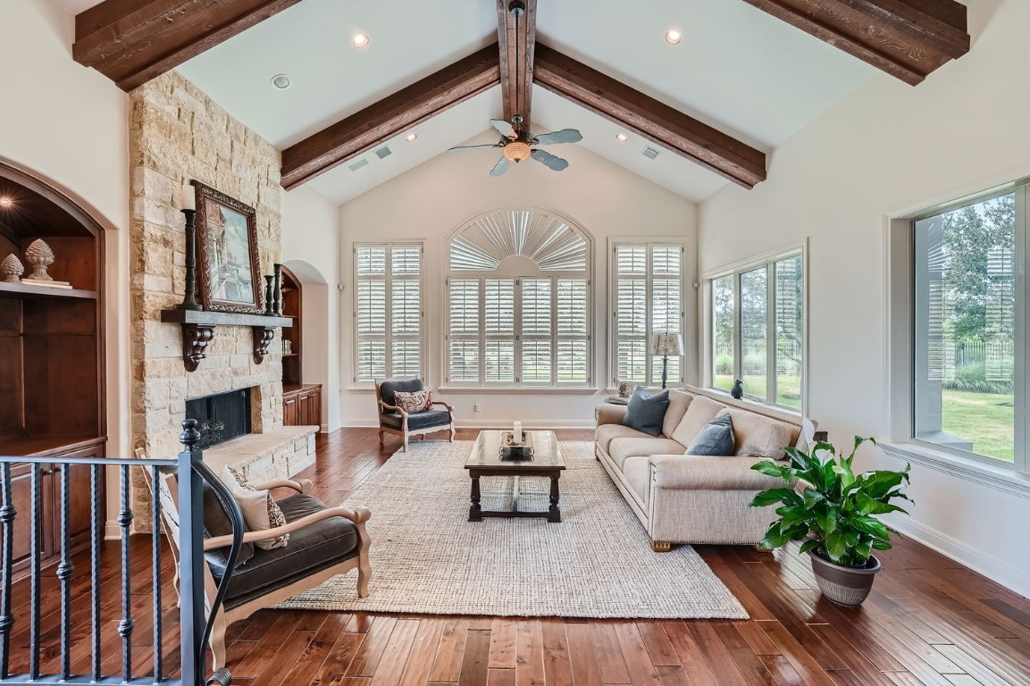 a living room with furniture potted plant floor to ceiling windows and a flat screen tv