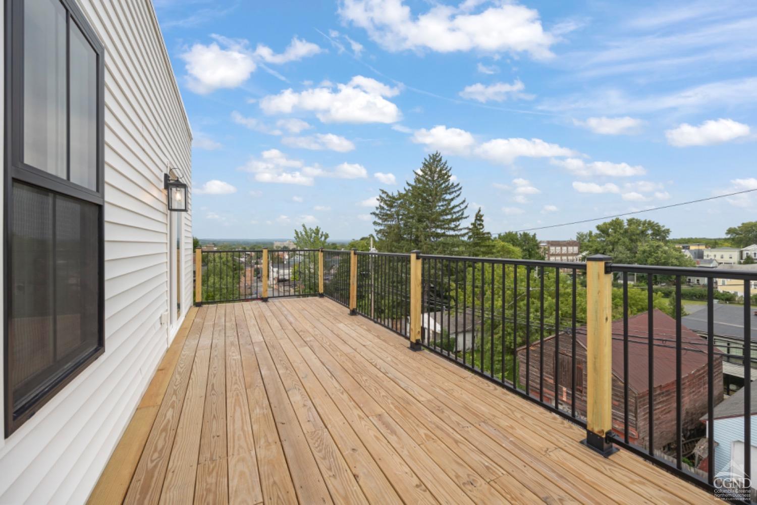 a view of a balcony with wooden floor and city view